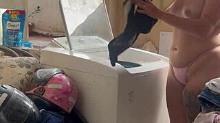 She washes clothes, unaware of neighbor watching