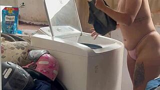 She washes clothes, unaware of neighbor watching