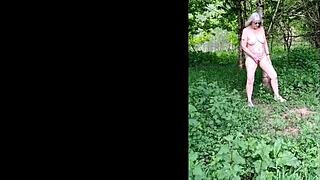 this naughty housewife is naked and wanking in the forest, reaching orgasm outdoors.