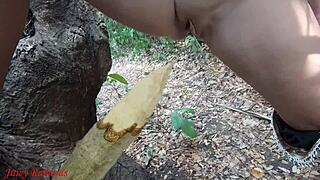 Perverted slut squirts piss from wooden stake in forest
