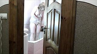 Does this naked sexy blonde in the bathroom notice her pervert roommate watching her masturbate and cum?